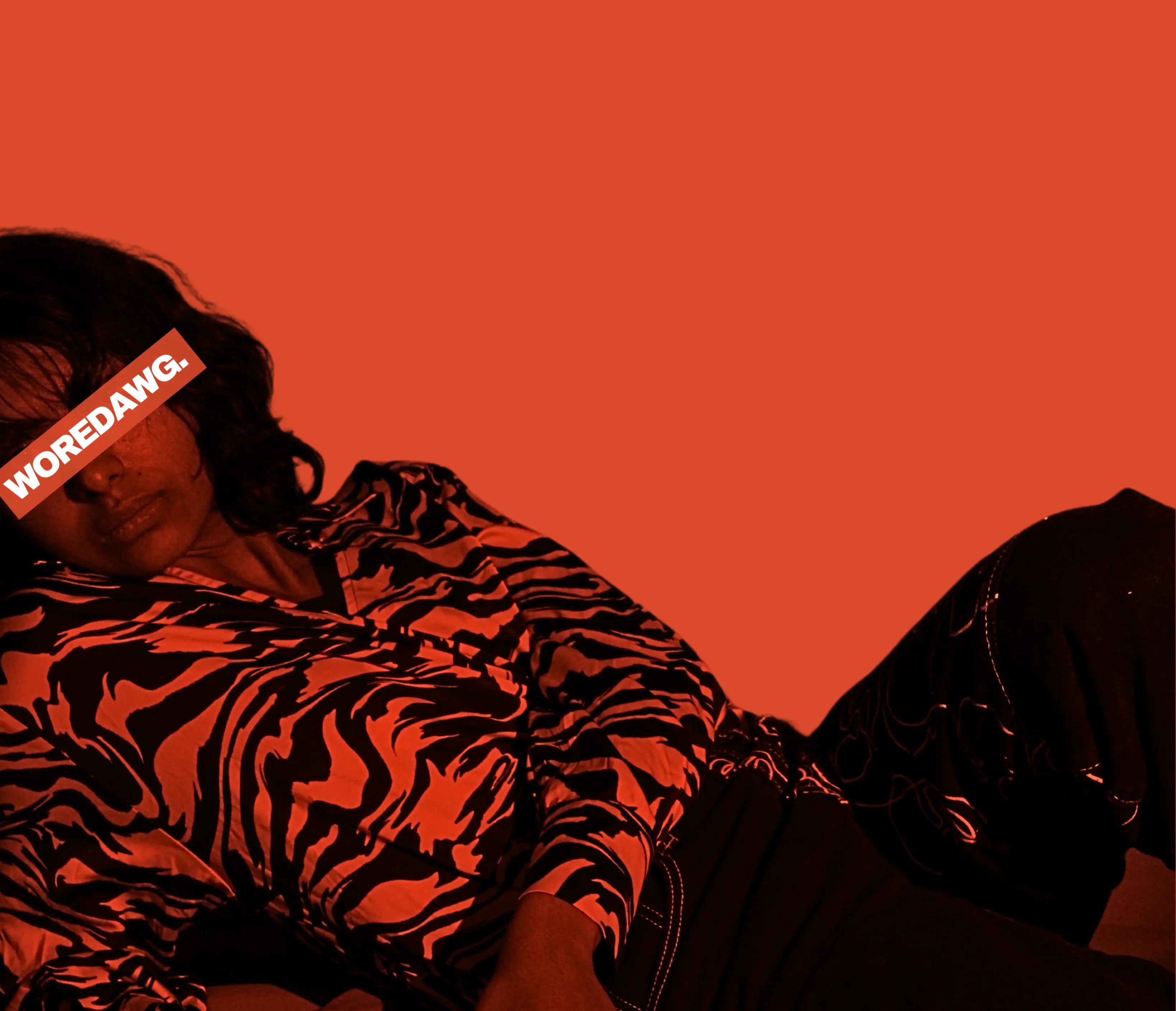 Person wearing a zebra print jacket against an orange background with 'WOREDAWG.' text.